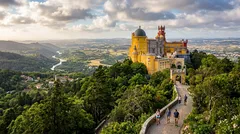 Pohľad na hrad Pena v Sintre s turistami na chodníku a zeleným údolím